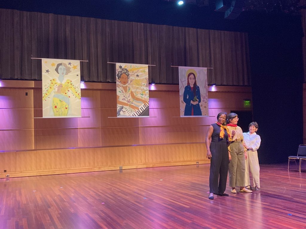 Three canvas collages hung above a stage with 3 actors emoting below them.