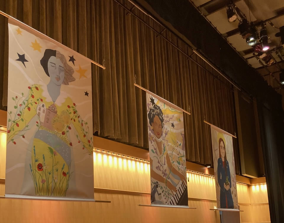 Display of three art pieces, suspended from the air in museum lighting at an angle.